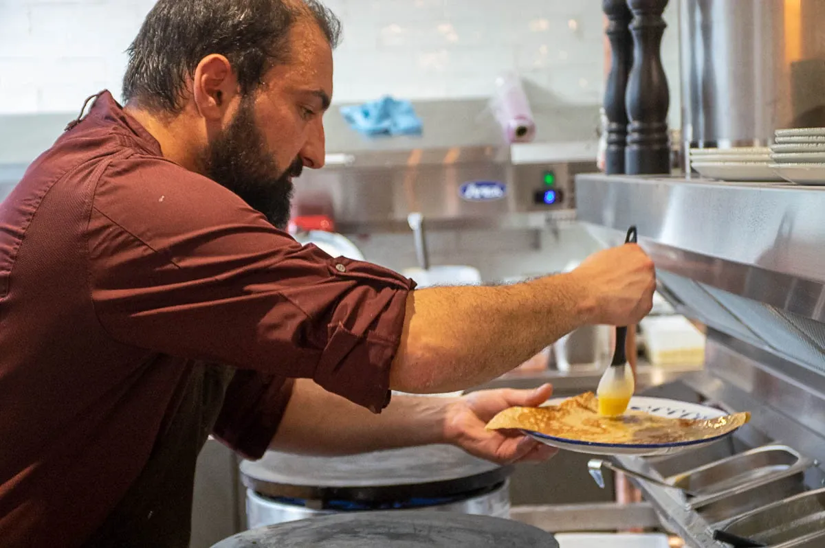Le crêpier dresse une assiette en cuisine